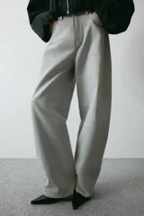 Pantalón de jean color gris claro, de tiro alto y diseño baggy con corte holgado en la cadera y piernas anchas estilo balloon.