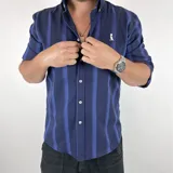 Camisa de hombre de algodón a rayas verticales azul marino y azul, con cuello italiano y manga tres cuartos.