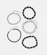 Kit de cinco pulseras de diseño variado, que incluye cadenas de eslabones plateados y pulseras de abalorios y piedras negras. Poseen cierre tipo langosta y cadena de ajuste.