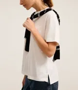 Blusa de manga corta confeccionada en algodón pima, con cuello redondo y diseño liso. Presenta un corte clásico con el bajo ligeramente más largo en la parte posterior.