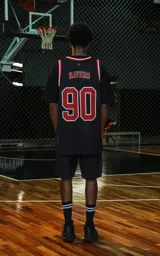 Musculosa deportiva negra con ribetes en cuello y sisas en rojo y blanco. Estampado frontal con la palabra "RAVERS" y el número "90" en rojo con borde blanco.