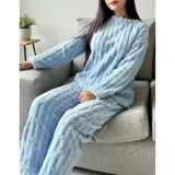 Pijama de dos piezas de tejido plush texturado con diseño de puntos en relieve, compuesto por un buzo de manga larga con cuello redondo y un pantalón largo de corte recto.