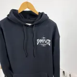 Canguro negro oversize con capucha y cordones ajustables. Estampa en la espalda con el texto "SAMPLER THE MINIMAL GARMENTS FACTORY DUXON INDUSTRIES" en color gris.