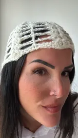 Gorro tipo beanie tejido al crochet con diseño calado y lentejuelas plateadas.