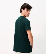 Remera de manga corta y cuello redondo, confeccionada en tejido de media malla con textura vertical. Presenta un diseño minimalista y versátil, ideal para un look casual.