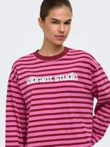 Remera de manga larga a rayas horizontales en tonos marrón y tostado, con cuello redondo y el texto "vibrant studio" estampado en el pecho.
