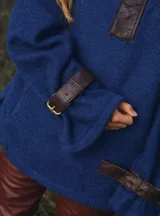 Buzo de tejido tipo lana color naranja con cuello de piel sintética, detalles en cuero marrón, correas ajustables con hebillas en cuello y mangas, y bolsillos laterales.