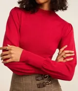 Suéter rojo de punto con cuello alto y mangas largas abullonadas.