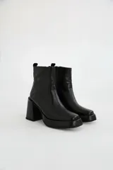Bota de cuero marrón con textura croco, taco alto ancho y plataforma delantera, con cierre lateral y puntera cuadrada.