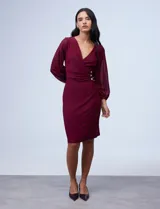 Vestido azul de RM Richards en seda fría, con escote en V cruzado, cintura drapeada, mangas largas de gasa y aplique de botones en el lateral.