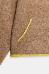 Chaqueta de punto de textura bouclé en color marrón, con cuello subido, manga larga y cierre frontal con cremallera. Presenta detalles de ribetes y acabados en color verde lima a contraste en cuello, cierre, bolsillos y puños.