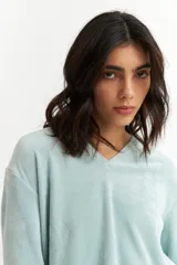 Remera celeste de plush con cuello en V y mangas largas.