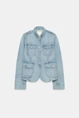Cazadora de denim de corte entallado, color celeste, con cuello subido, manga larga y cierre frontal con botones metálicos. Cuenta con bolsillos con solapa en el pecho y en la parte inferior delantera, además de presillas en los hombros.