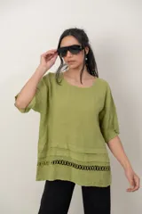Blusa de lino color blanco, de corte amplio, con escote redondo, mangas cortas y detalle de guarda calada horizontal en la parte inferior.