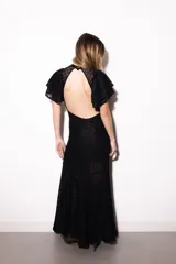Vestido largo negro de encaje transparente con diseño geométrico, mangas cortas con volados y cuello alto.