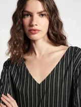 Blusa de cuello en V con estampado geométrico de líneas blancas sobre fondo azul marino.