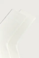 Medias de algodón color blanco crudo, con diseño acanalado en toda la prenda y acabado elástico en el puño.