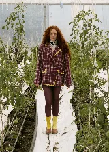 Blazer sastrero de corte oversize, con cuello solapa, manga larga y cierre frontal con botones. Presenta un diseño a cuadros en tonos bordó y blanco, con detalles de costuras bordadas en hilo amarillo en los bolsillos y el ruedo. Incluye forro interior de satén.