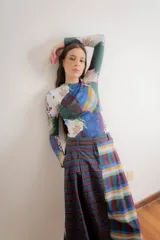 Remera de manga larga confeccionada en algodón elastizado, con cuello redondo y diseño ajustado al cuerpo. Presenta un estampado de rombos finos con motivos florales en tonos azules sobre una base de color marrón oscuro.