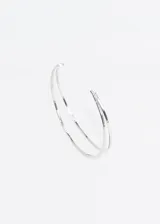 Brazalete abierto de metal plateado con doble línea.