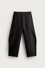 Pantalón de corte relajado confeccionado en tejido de algodón, con cintura elástica y detalle de pliegues estructurales en las perneras. Cuenta con bolsillos frontales y un bolsillo trasero de plastrón.