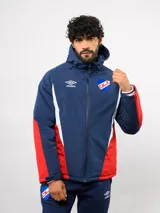 Campera de abrigo Umbro del Club Nacional de Football, con diseño de bloques de color en azul, blanco y rojo. Cuenta con capucha ajustable, cierre frontal y logo de la marca junto al escudo del club en el pecho.