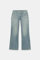 Jeans de tiro bajo y corte flare, confeccionados en denim de lavado claro. Presentan bolsillos de plastrón en el frente, trabillas para cinturón y cierre frontal con cremallera y botones metálicos.