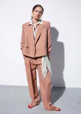 Blazer crop de mezcla de lino y viscosa, color tostado con estampado de rayas verticales, cuello en pico con solapas de muesca, bolsillos de ribete laterales y cierre delantero de un botón.