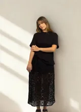 Falda larga de encaje negro con forro corto. Tiene elástico en la cintura.