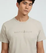 Remera de algodón color beige, de corte comfort con cuello redondo y manga corta. Presenta estampa frontal localizada con texto "NAUTIC CLUB" y un logotipo de velero.