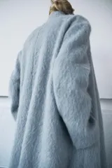 Abrigo recto de corte clásico confeccionado en una mezcla de lana Manteco y alpaca. Presenta cuello solapa, cierre frontal con un único botón visible y mangas largas. Diseño de textura suave y acabado elegante.