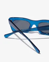 Lentes de sol unisex Hawkers Paula Echevarría, modelo Lauper, con montura rectangular de acetato color azul eléctrico y lentes grises.