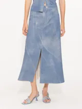 Falda midi de cuero ovino celeste con recortes diagonales y tajo frontal.