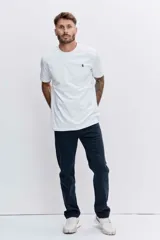 Remera blanca de corte clásico con cuello redondo y manga corta. Presenta un pequeño bordado distintivo en el pecho.