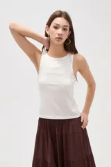 Musculosa de corte al cuerpo con cuello redondo y diseño sin mangas, confeccionada en tejido liso.