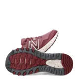 Championes de trail running New Balance modelo T410, color bordó con detalles en blanco crema y gris. Presentan una estructura de malla técnica con refuerzos sintéticos, logo N lateral y entresuela con diseño moteado.