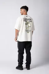 Remera oversize de algodón color crudo con un pequeño estampado lateral en negro y un gráfico grande en la espalda con hongos y texto.