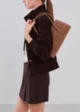 Minifalda marrón oscuro de corte recto, con diseño liso y cierre cruzado simulado.