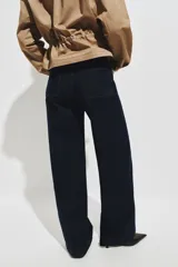 Pantalón de jean color azul oscuro con diseño de pernera ancha, talle alto, bolsillos diagonales al frente y raya marcada planchada en el centro de las piernas.