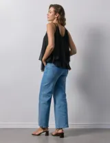 Blusa negra de gasa con breteles finos trenzados, escote redondo y capas superpuestas de encaje y gasa en el frente.