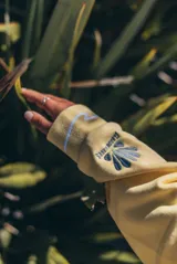 Hoodie amarillo con capucha, de corte holgado y diseño de espalda con bordado gráfico de olas, sol y la inscripción 'Glassy Waves'. Presenta detalles de ondas bordadas en el ruedo inferior.