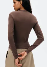 Remera marrón de corte ajustado, cuello redondo y mangas largas.