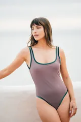 Traje de baño entero color visón con bordes de terciopelo verde inglés y detalle de óvalo en la espalda.