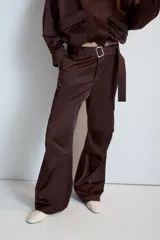 Pantalón cargo de tiro medio confeccionado en tejido satinado color beige, de corte recto y holgado. Cuenta con bolsillos laterales con solapa, bolsillos frontales y un cinturón integrado del mismo tejido con hebilla metálica.