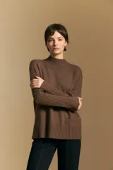 Polera de cuello alto confeccionada en tejido de punto negro, con diseño de textura acanalada en cuello, puños y ruedo, y trama vertical en mangas y espalda.