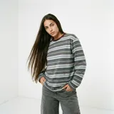 Remera de manga larga con diseño de rayas horizontales en tonos gris, celeste y bordó. Presenta cuello redondo en color bordó y un pequeño bordado en la parte inferior frontal.