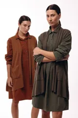 Chaleco de diseño fluido con escote cruzado y lazo ajustable en la cintura. Presenta un corte largo y versátil, ideal para superponer en diferentes looks.