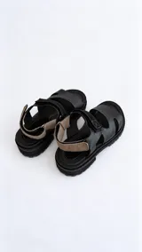 Sandalias de cuero marrón con cierre de velcro en la tira del empeine, plantilla tostada, suela flatform negra y detalles interiores en color rojo.