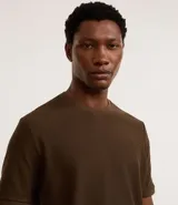 Remera de manga corta con cuello redondo, confeccionada en tejido texturizado de algodón y poliéster.