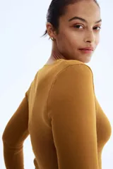 Remera ajustada de punto fino color mostaza, con escote cuadrado pronunciado, manga larga y tapeta de botones decorativa en el frente.